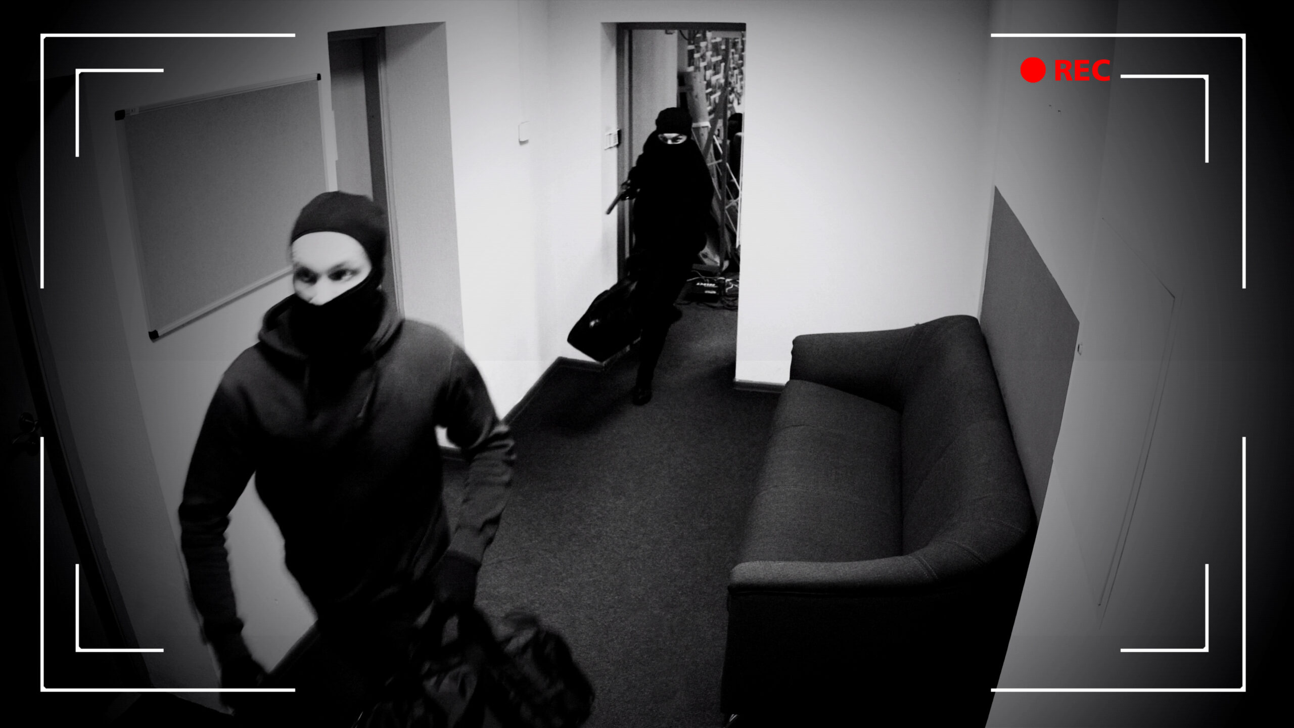 This image portrays a scene captured by a CCTV security camera, displaying a black-and-white feed of an interior space.