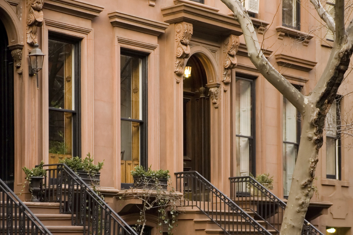 Elegant brownstone facade with ornate entryway and iron stair railings.