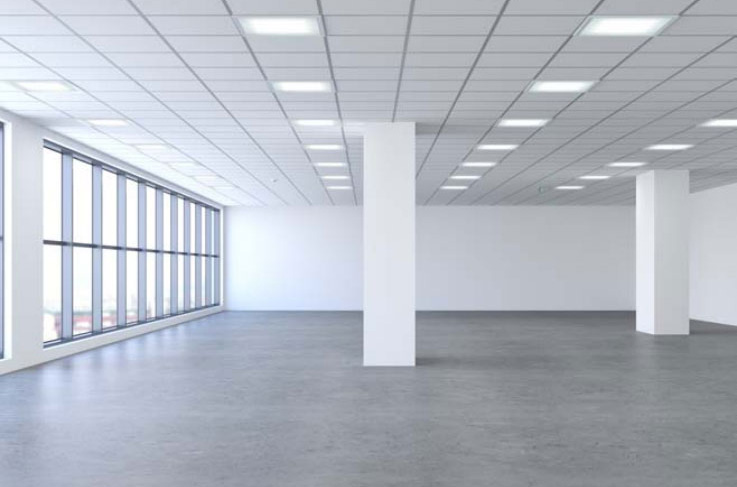 Empty commercial space with white columns and large windows.